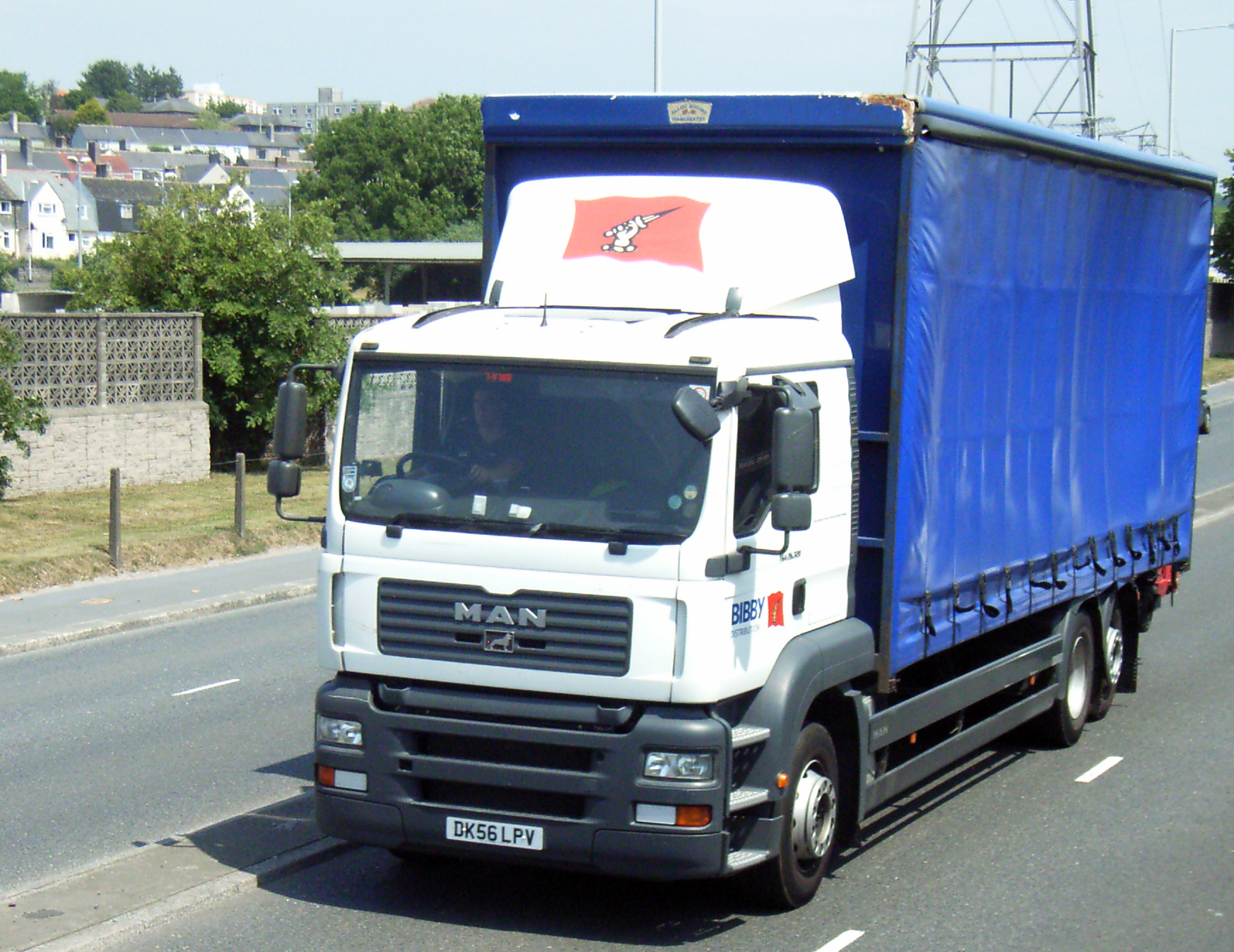 a blue and white truck driving down a road