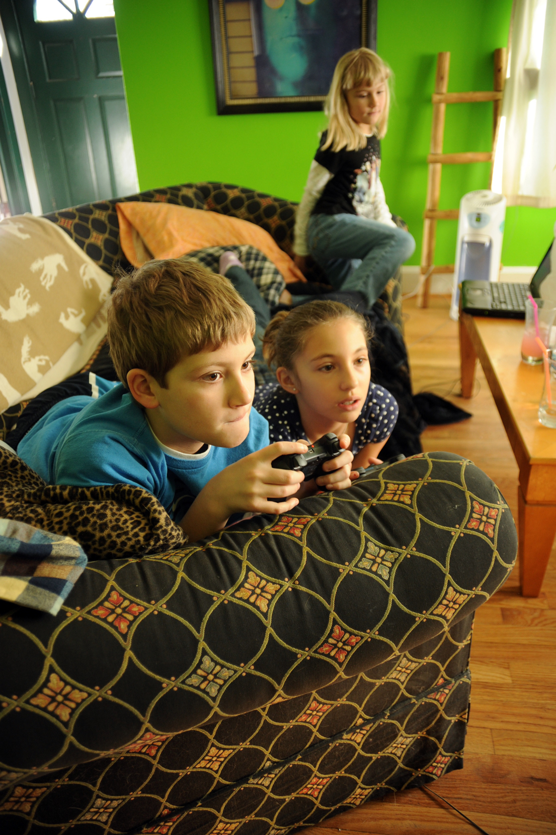 three children playing on the wii in the living room