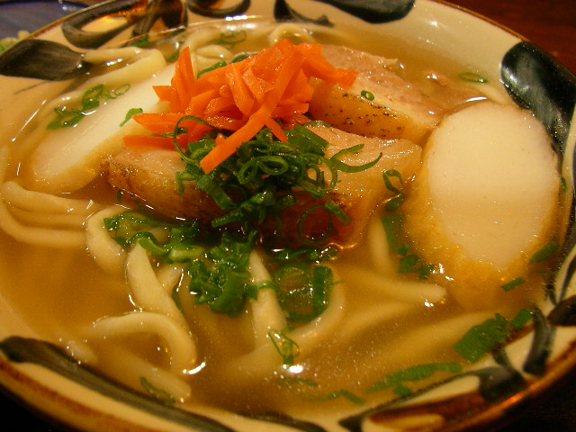 a meal on a plate with soup and noodles