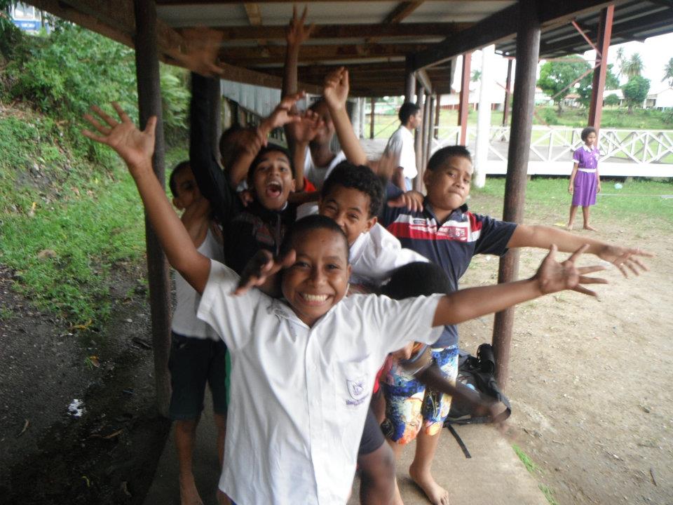 a group of children standing in front of a building