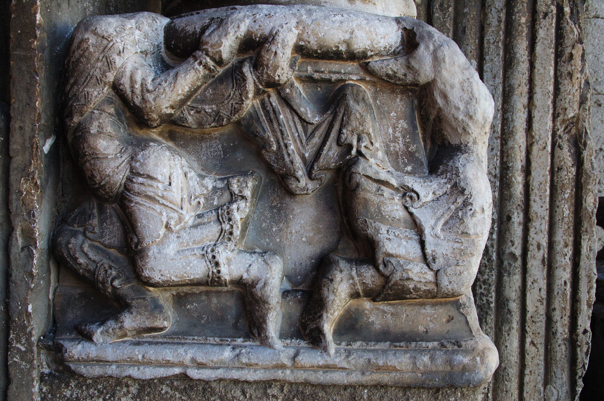 an artistic relief in stone depicting the fighting of agromia