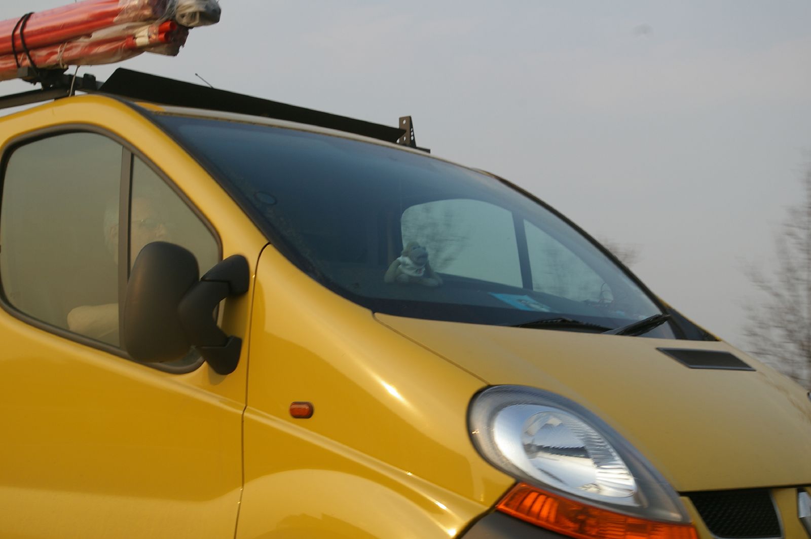 a yellow van with the top up and a bike on the roof