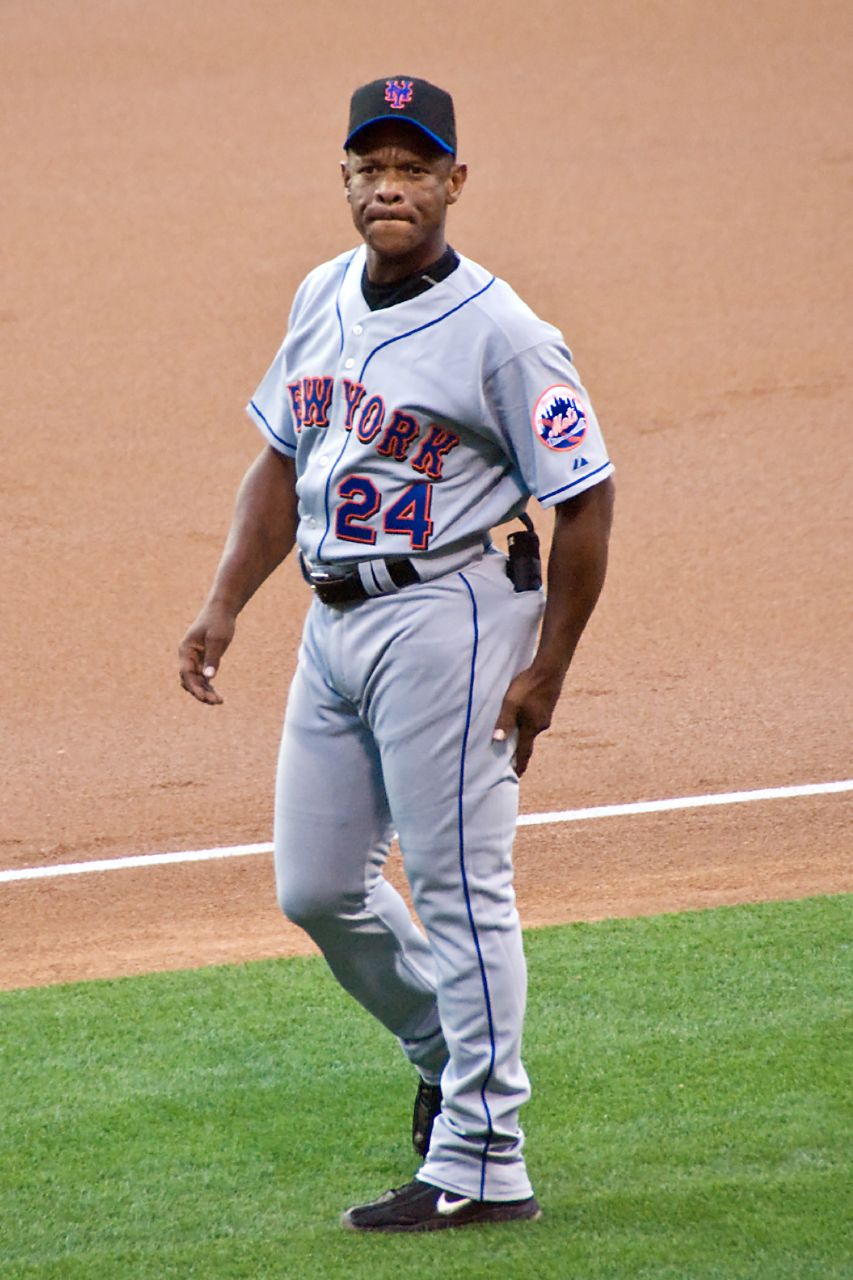 a baseball player stands on the field in his uniform