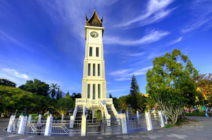 a white clock tower in front of some blue sky