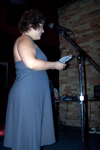 the woman is holding soing by the microphone