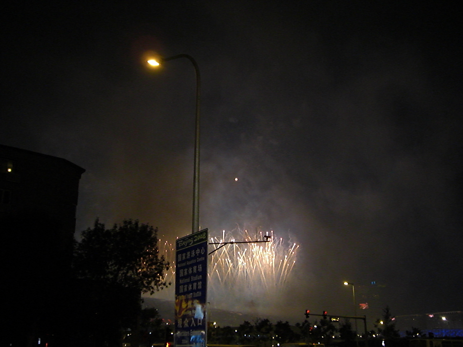 some fireworks that are in the air with trees around