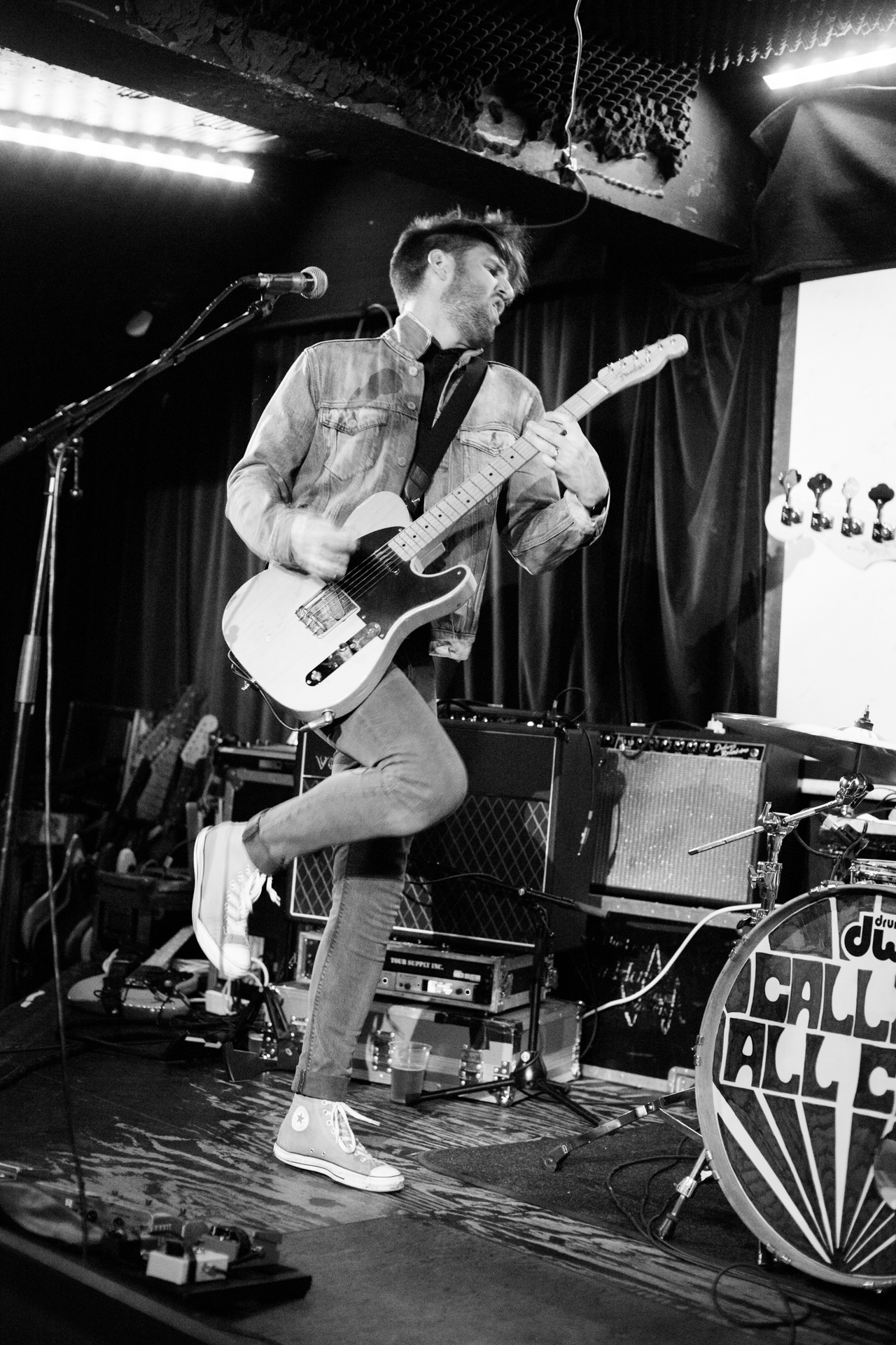 a man is playing guitar while other people watch