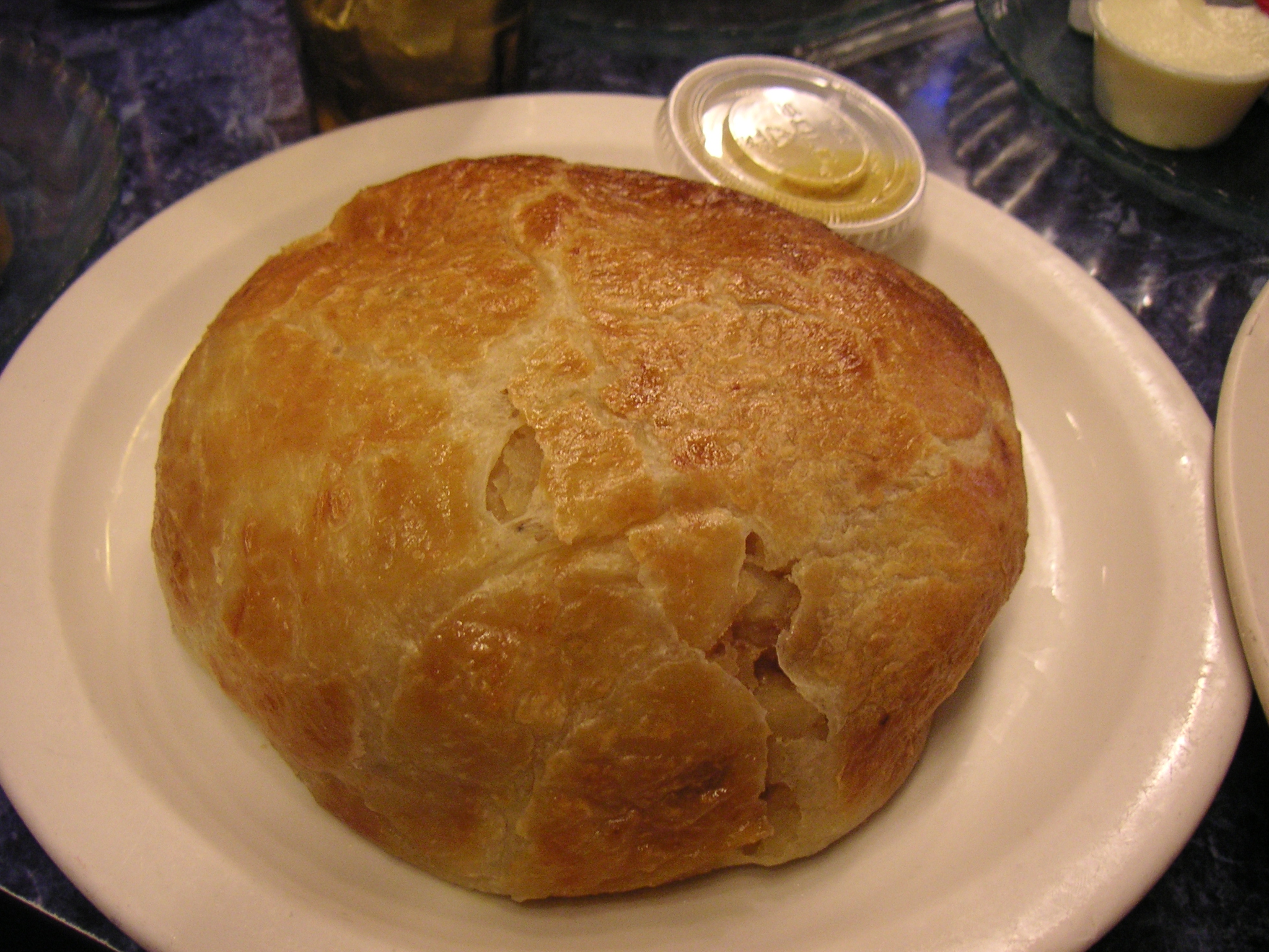 this is a closeup of a large, round bread with an oil container in the center