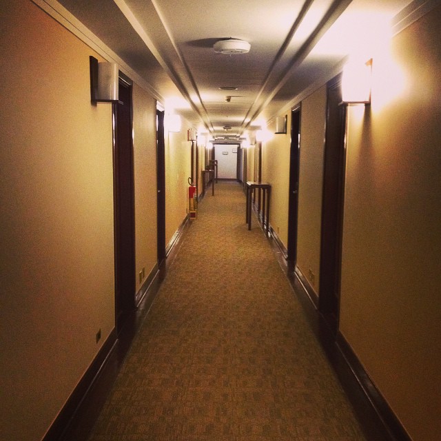 a dark hallway leads to some doors and another hallway