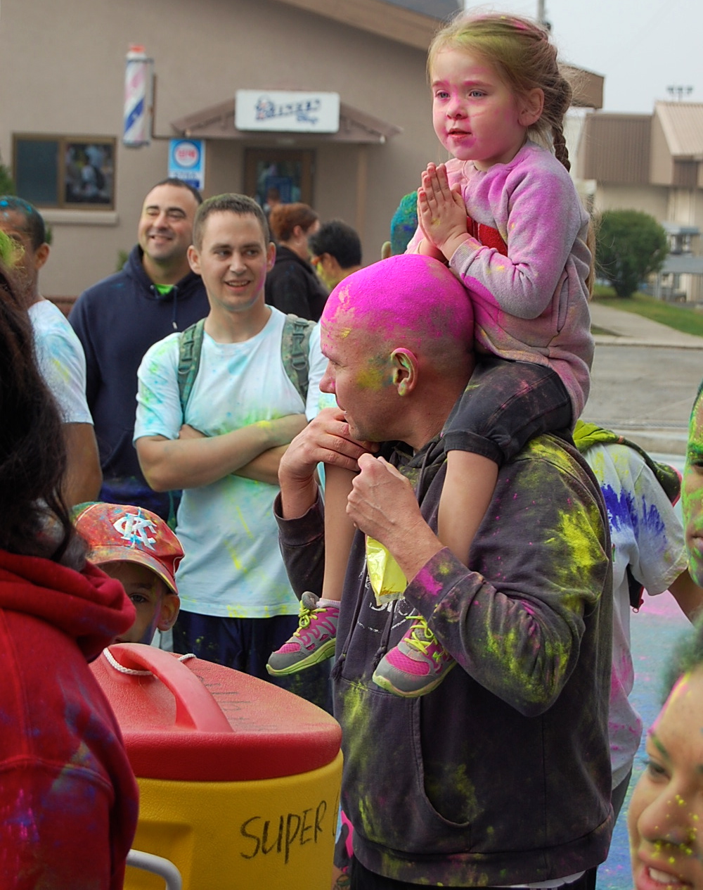a woman holding a small girl in her arms as people watch