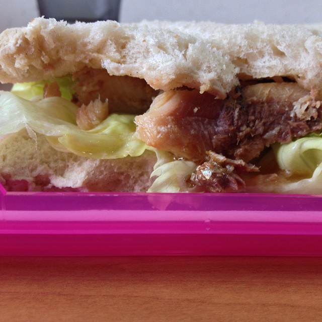 a half eaten sandwich in a plastic container