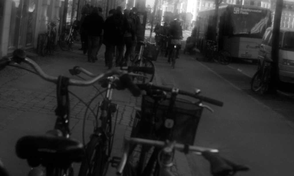 a black and white po shows the back end of some parked bicycles