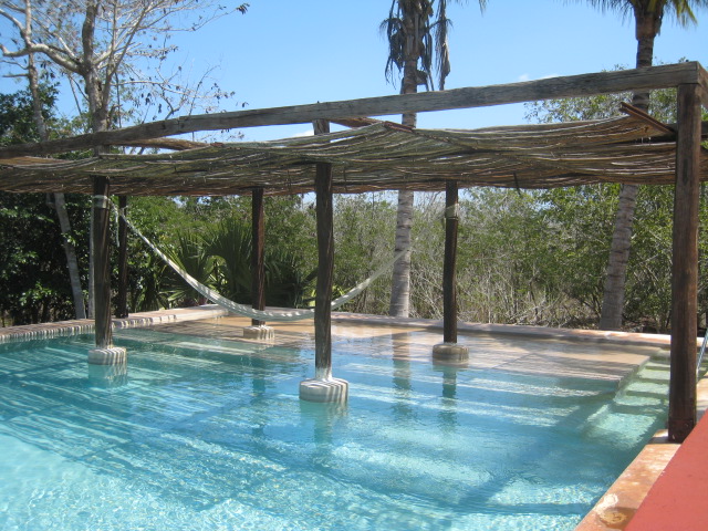 a pool with hammocks and a hammock in the middle