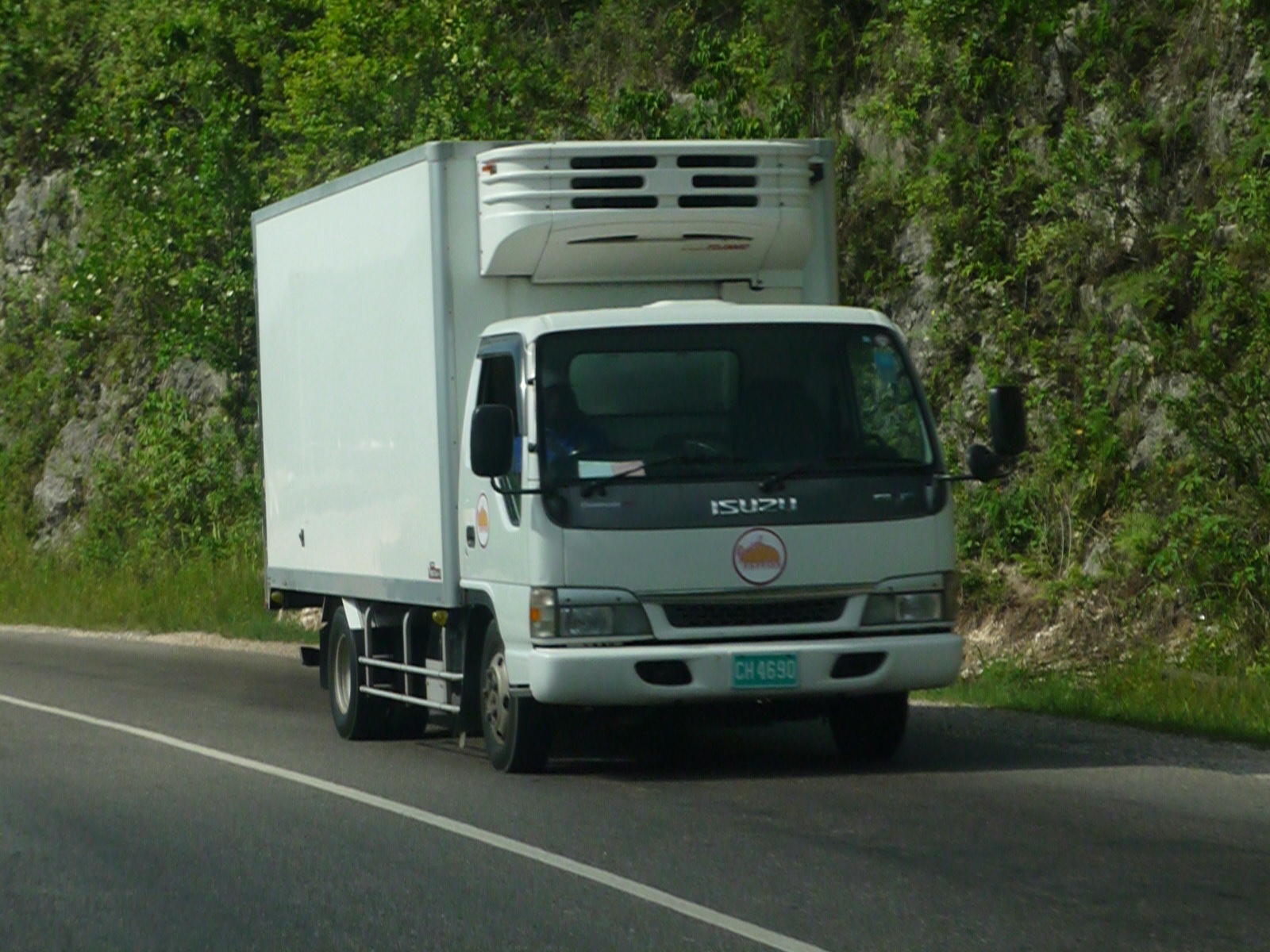 a truck with a flat bed driving down the street