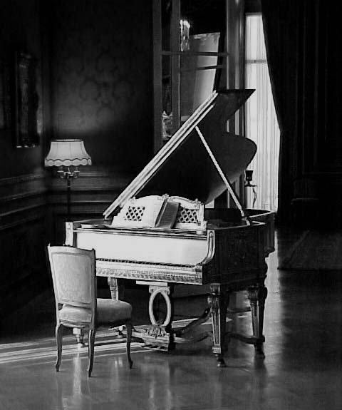 a grand piano sits in an empty room