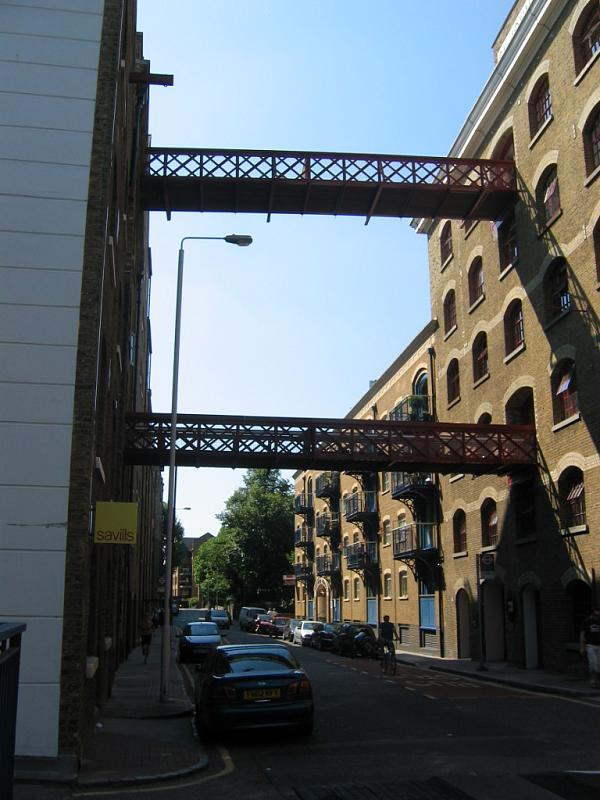 a street sign is posted above a city sidewalk