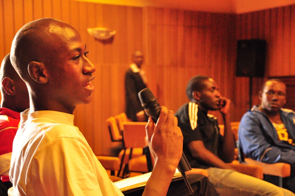 an african american  talks while standing in front of a microphone