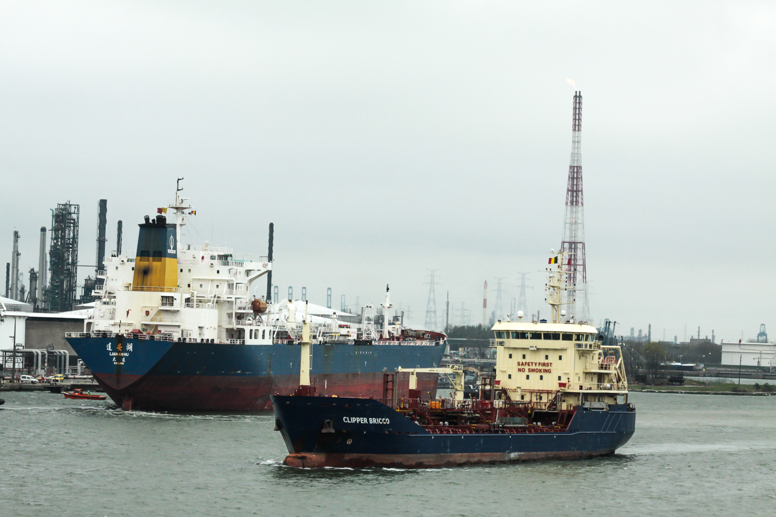 two large ships are anchored at a dock