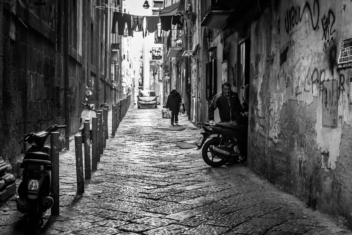 a black and white image of a narrow street