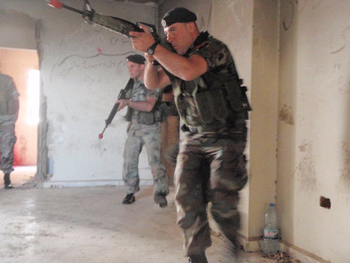 a soldier holding a gun with two others in the background