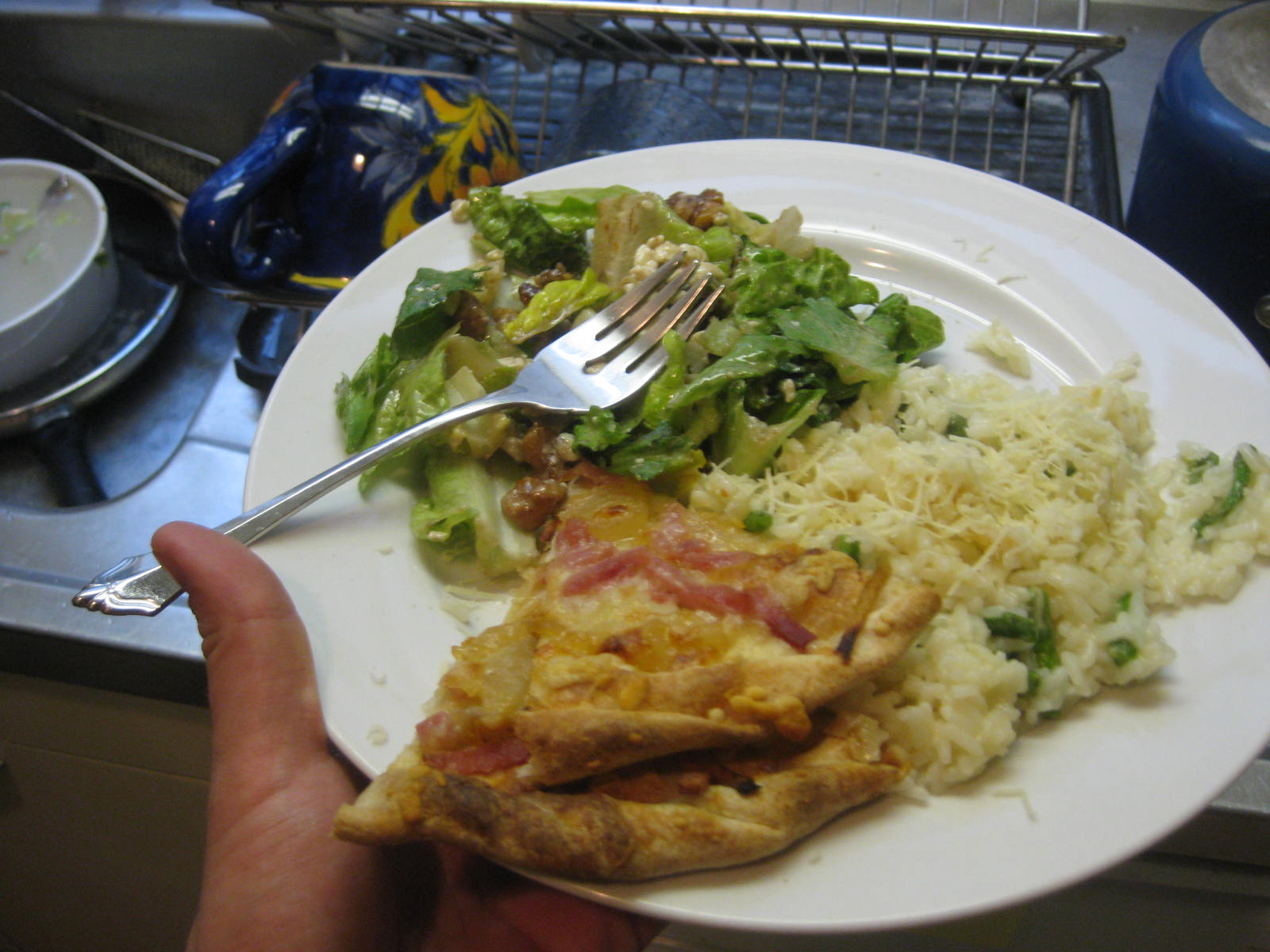 a piece of pizza and rice with a fork in a plate