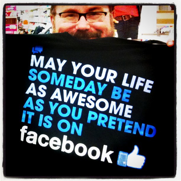 a man holding a large t - shirt with the quote facebook written on it