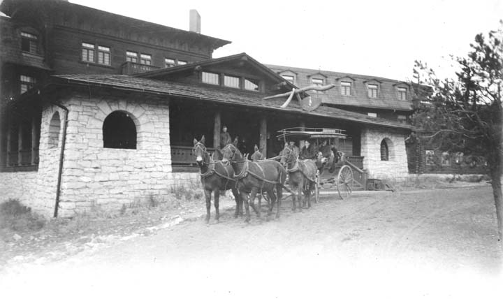 horses are pulling a wagon that is near a building