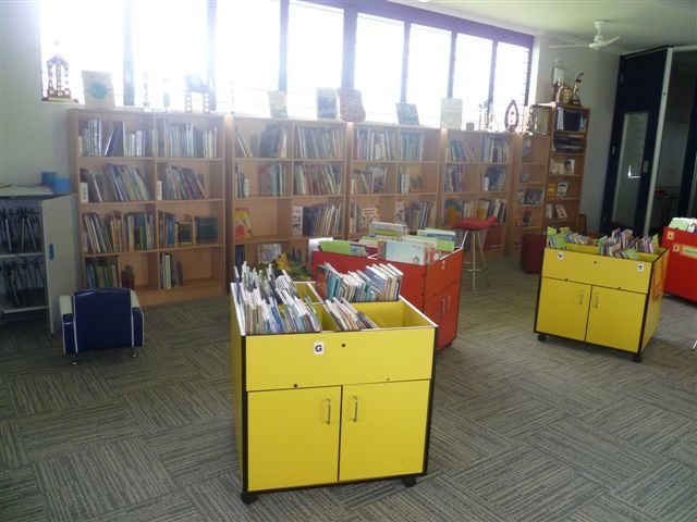 a room full of books with several filing carts