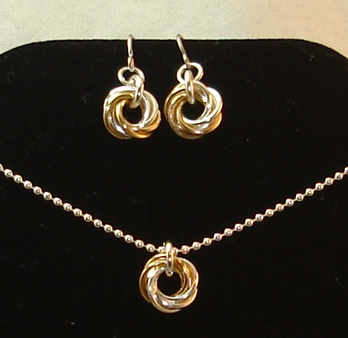 a necklace and earrings are shown on a black display