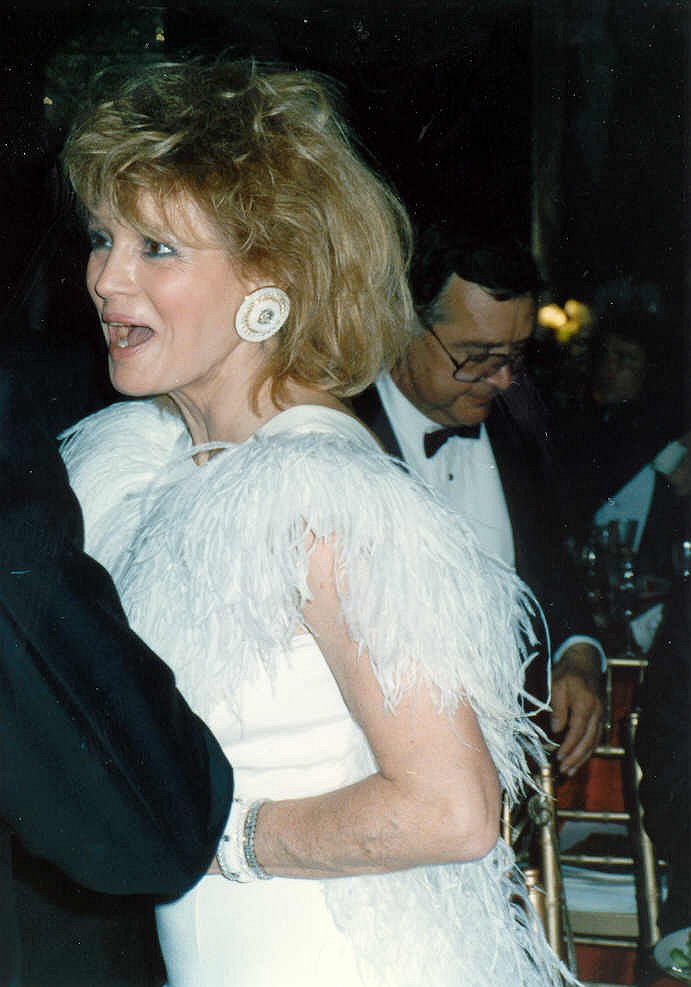 a woman in a feather dress and a man in suit