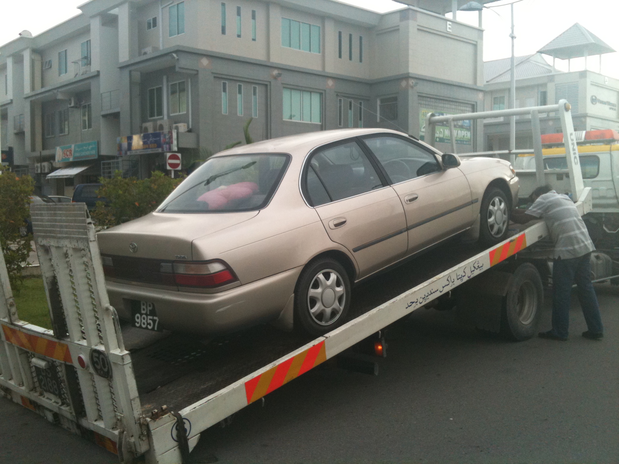 a car sitting on the back of a flat bed trailer