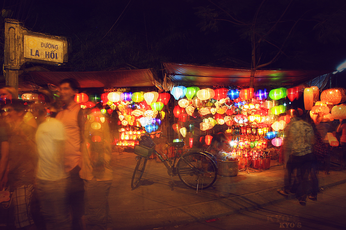 people walk near an asian lighted market in the evening