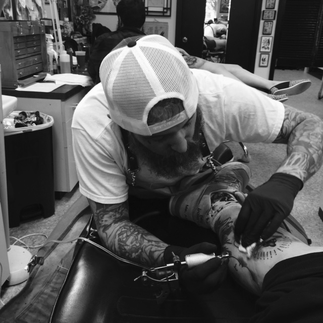 a man getting a tattoo done on his right arm