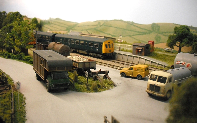 several toy train trains and vehicles next to a country town