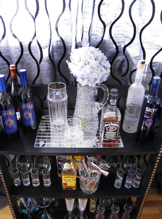 various liquor bottles and glasses on a bar shelf