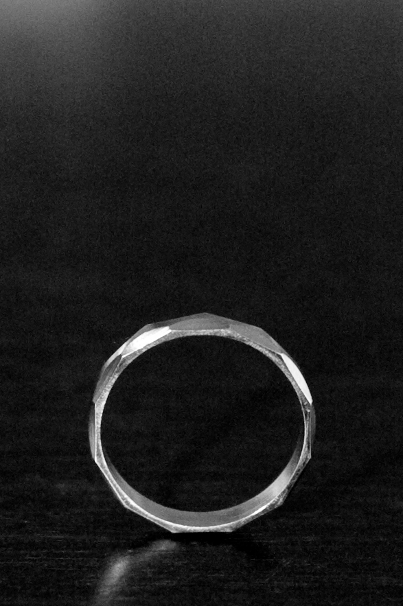 a wedding band sits on the surface in a dimly lit room