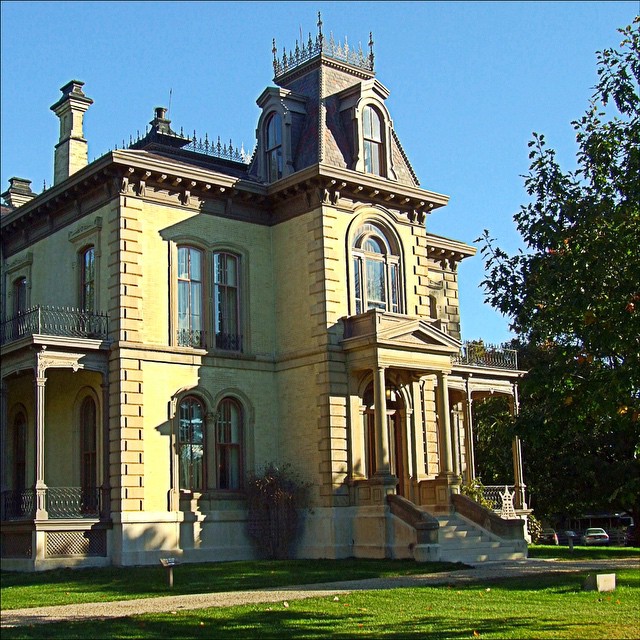 a large house is on the lawn with an open gate