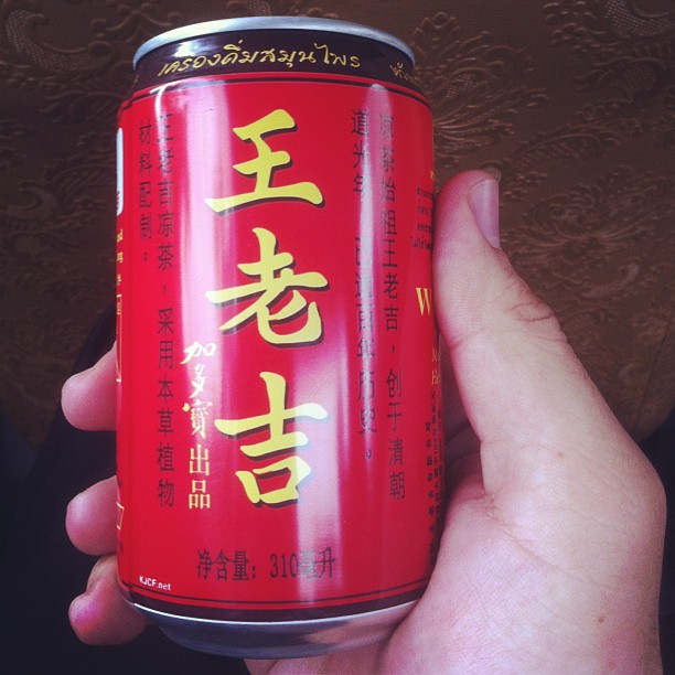 a person holding a can of food with asian writing