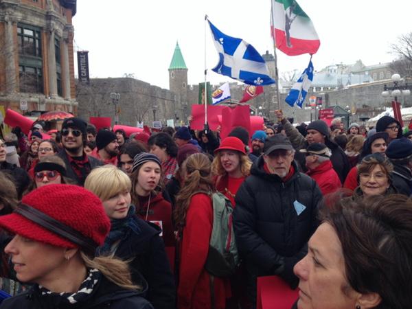 several people in a crowd with red hats, and flags