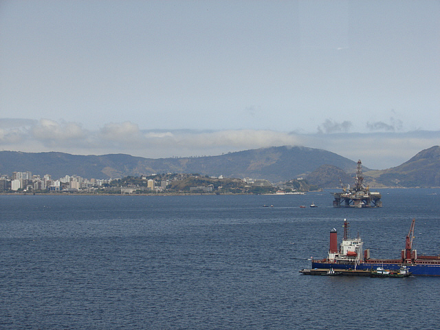 a tug boat passing a small barge floating on water