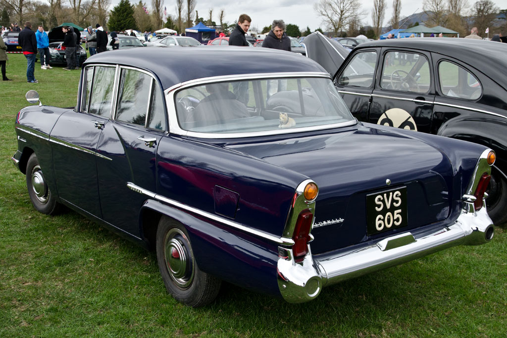 several classic cars on display in the grass
