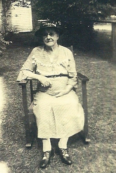 an old picture of an older woman sitting on a bench