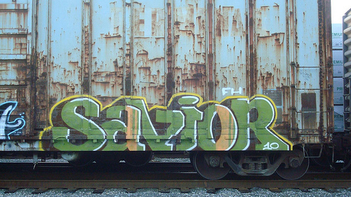 a train covered in graffiti sitting on top of tracks