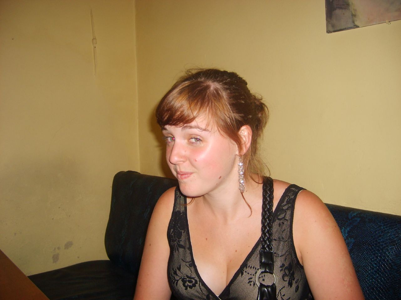 a young lady sitting on a couch with ear piercings