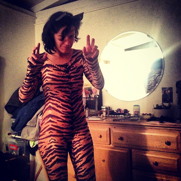 a girl in tiger animal print clothes posing for a camera