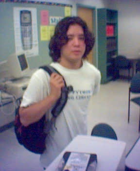 the blurry image shows the young man with long hair holding his backpack
