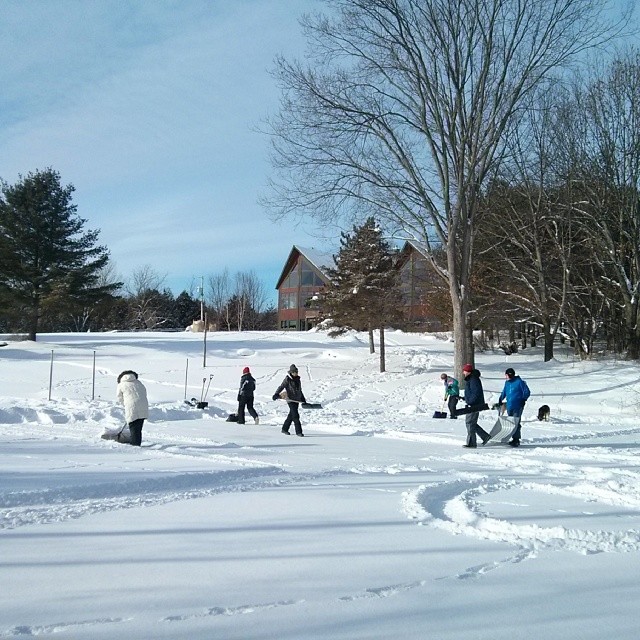 a group of people shoveling through snow