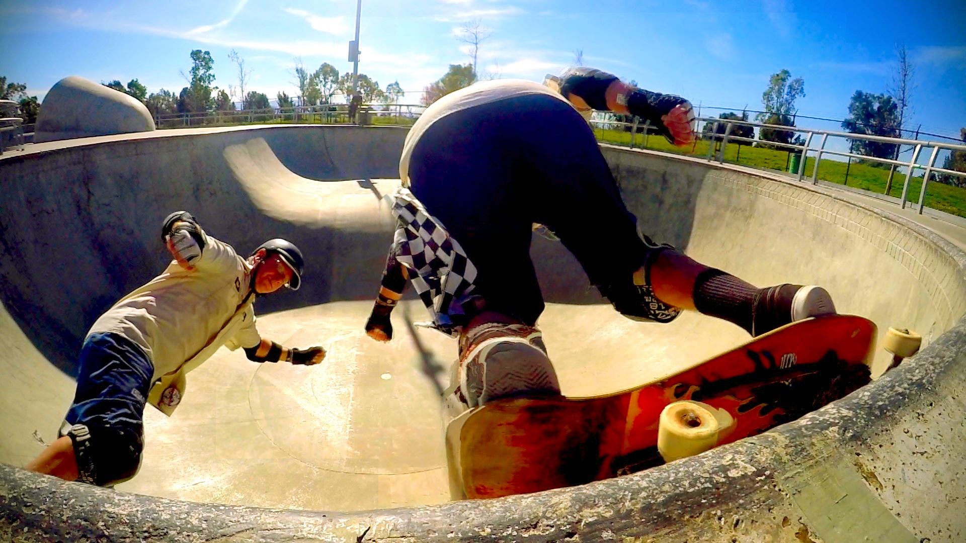 a pair of boys skateboard up and down a ramp