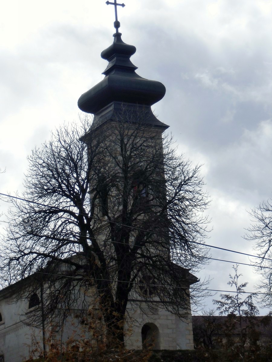 an old, small tower has a steeple with a cross at the top