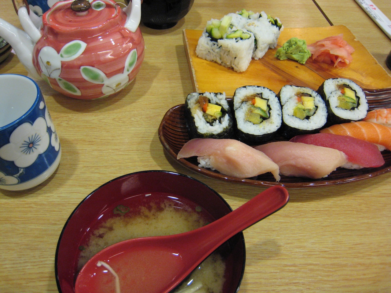 some sushi on some plates with other food items